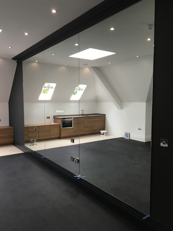 Frameless glass partition in loft conversion by Tring glaziers